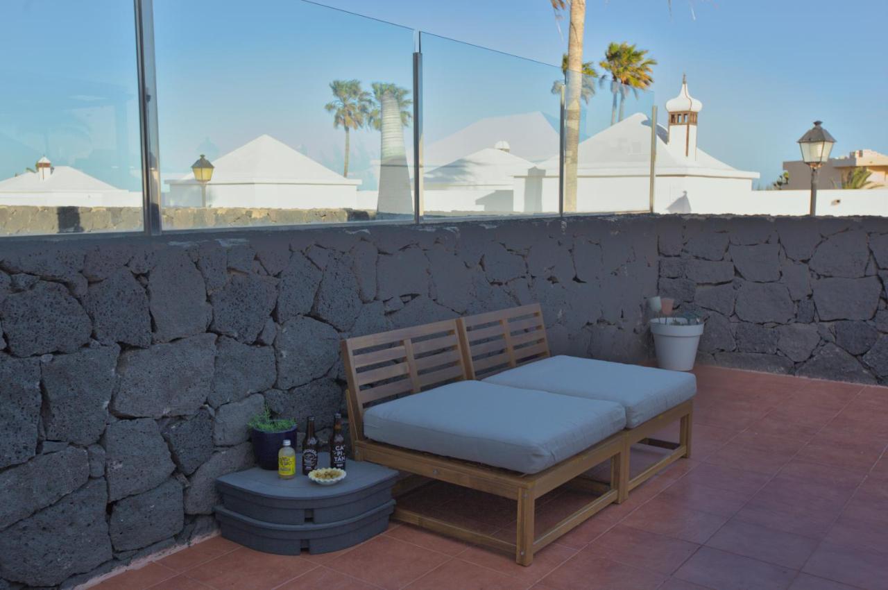 Terrasse abritée du vent de Casa Los Alisios avec parois en verre et mur de pierre volcanique