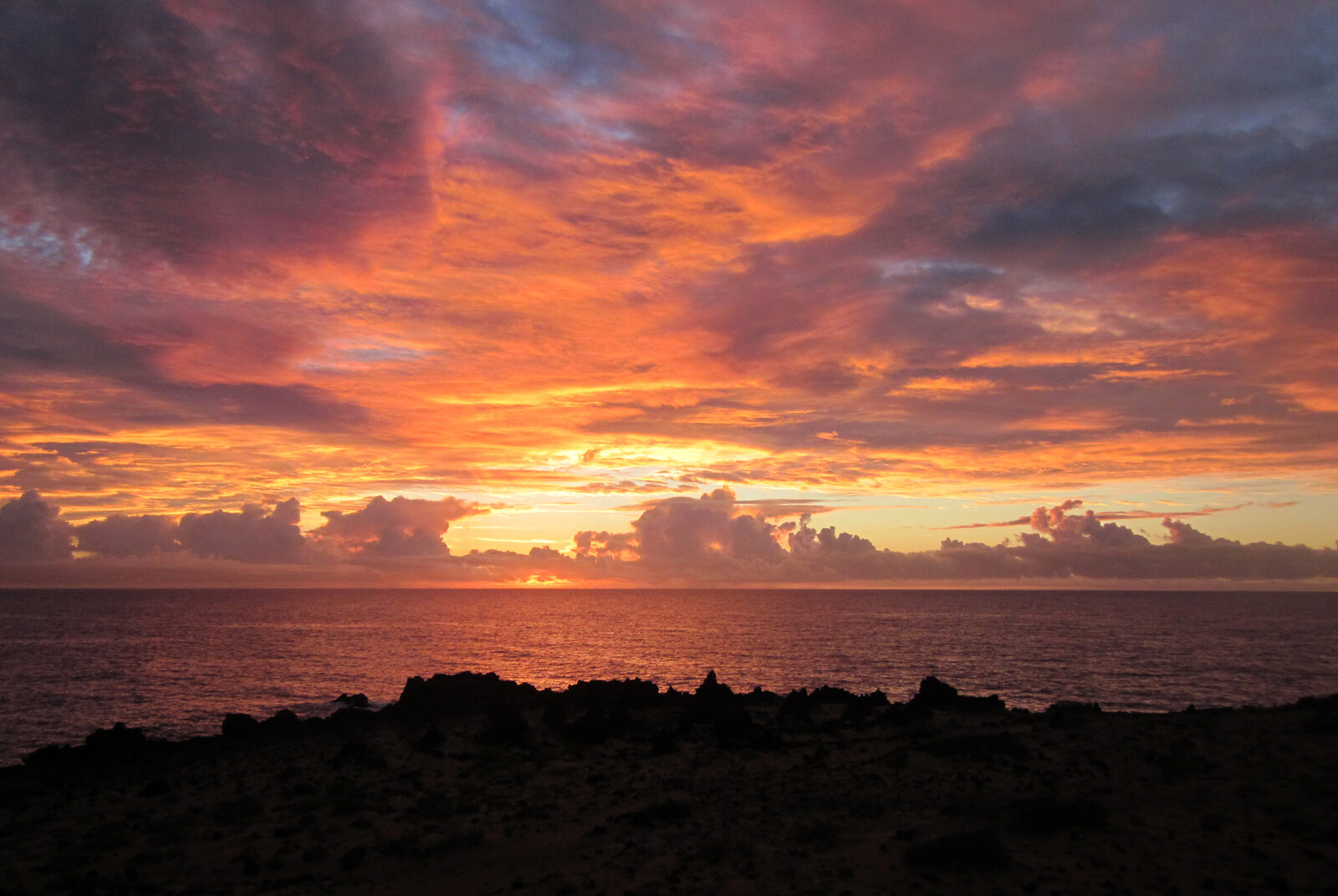 Fiery sunrise over the Atlantic and a lava shoreline on the east coast of Lanzarote