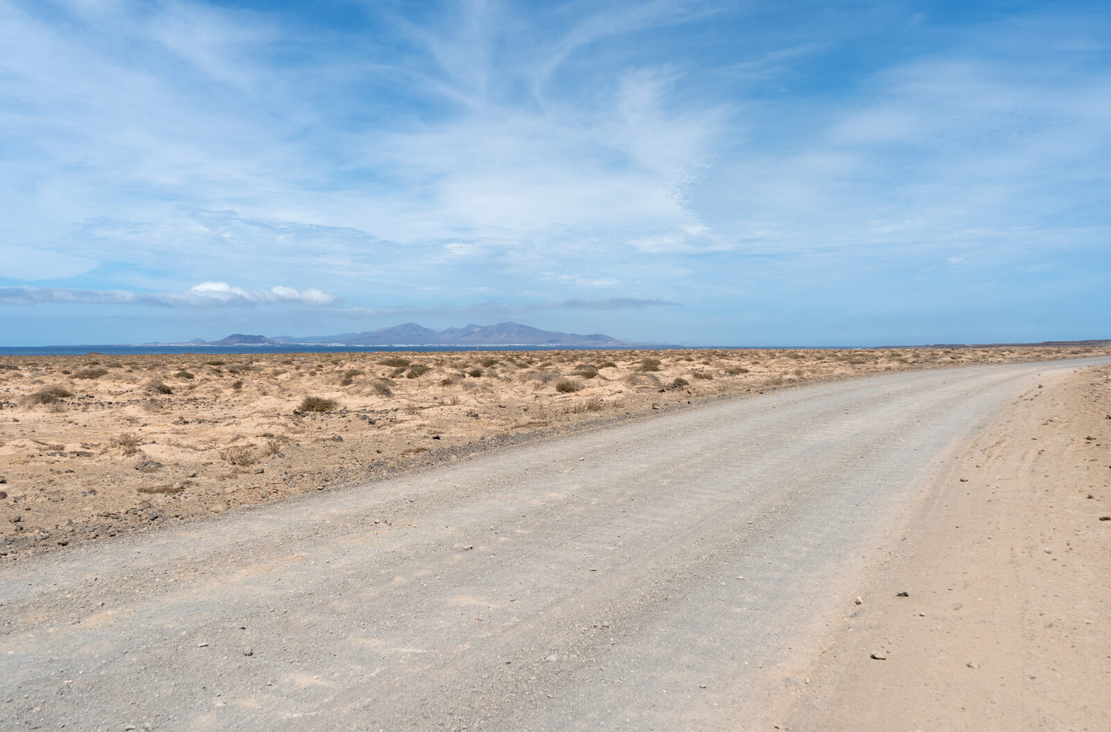 Route côtière vide entre Corralejo et El Cotillo, dans le nord de Fuerteventura, terrain volcanique ouvert typique des routes FV