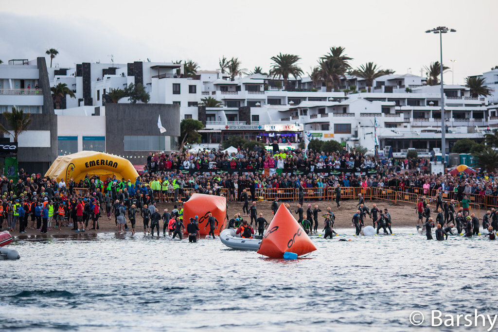 Spectators and ORCA buoys at the Ironman Lanzarote swim staging area, Playa Grande