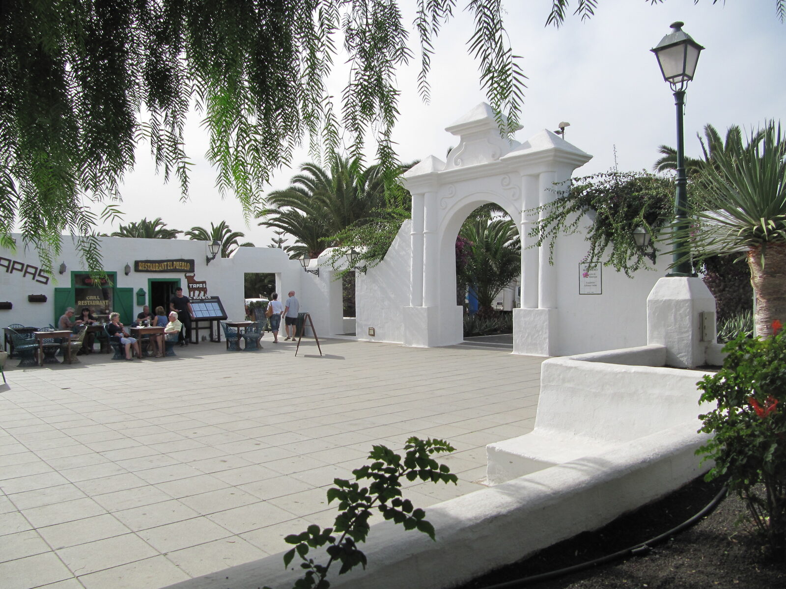 Plaza del Pueblo Marinero en Costa Teguise con edificios encalados de estilo tradicional y terrazas de restaurantes al aire libre