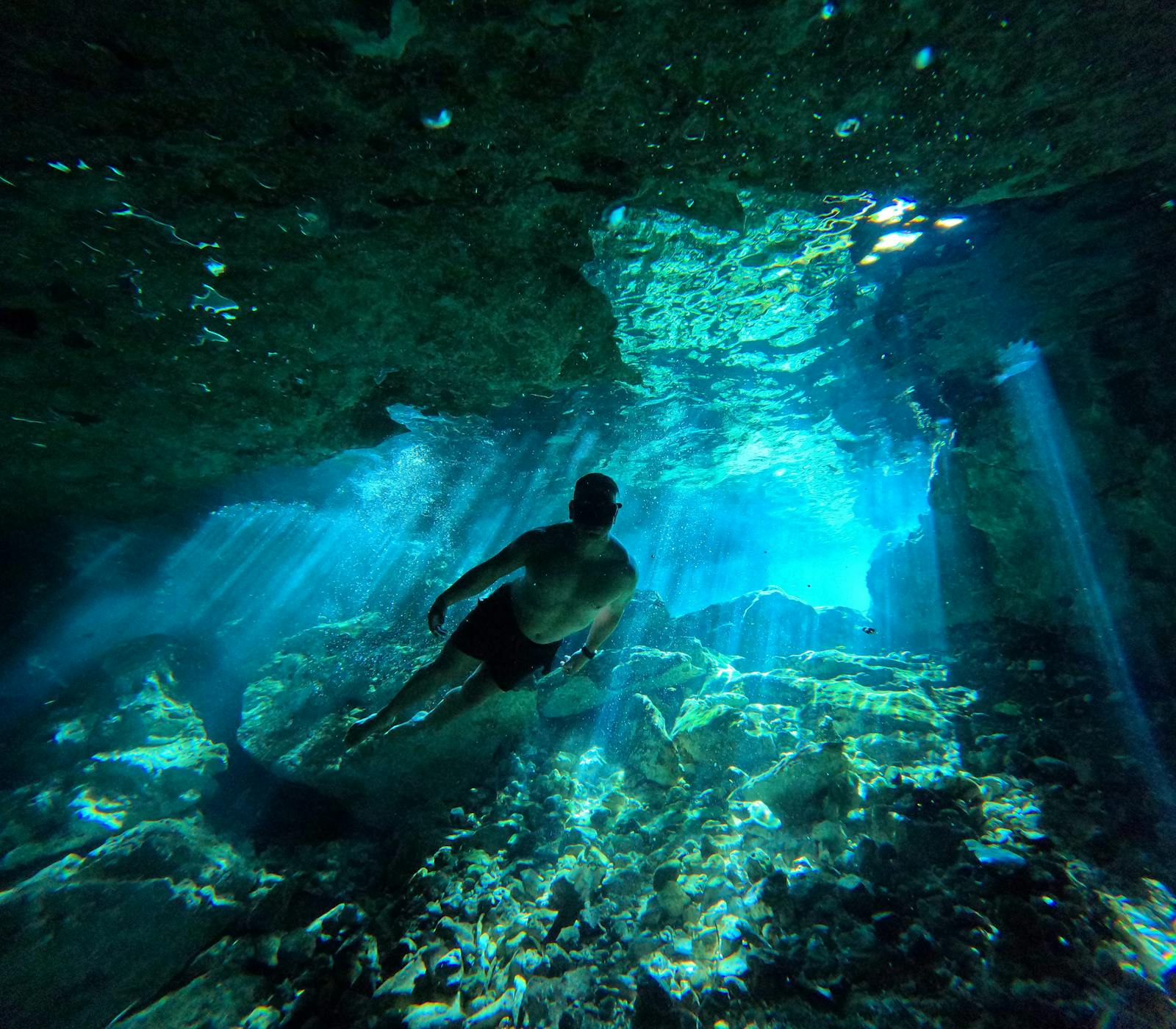 Cueva submarina con un buceador en silueta contra la luz azul, evocadora de La Catedral en Playa Chica, Lanzarote