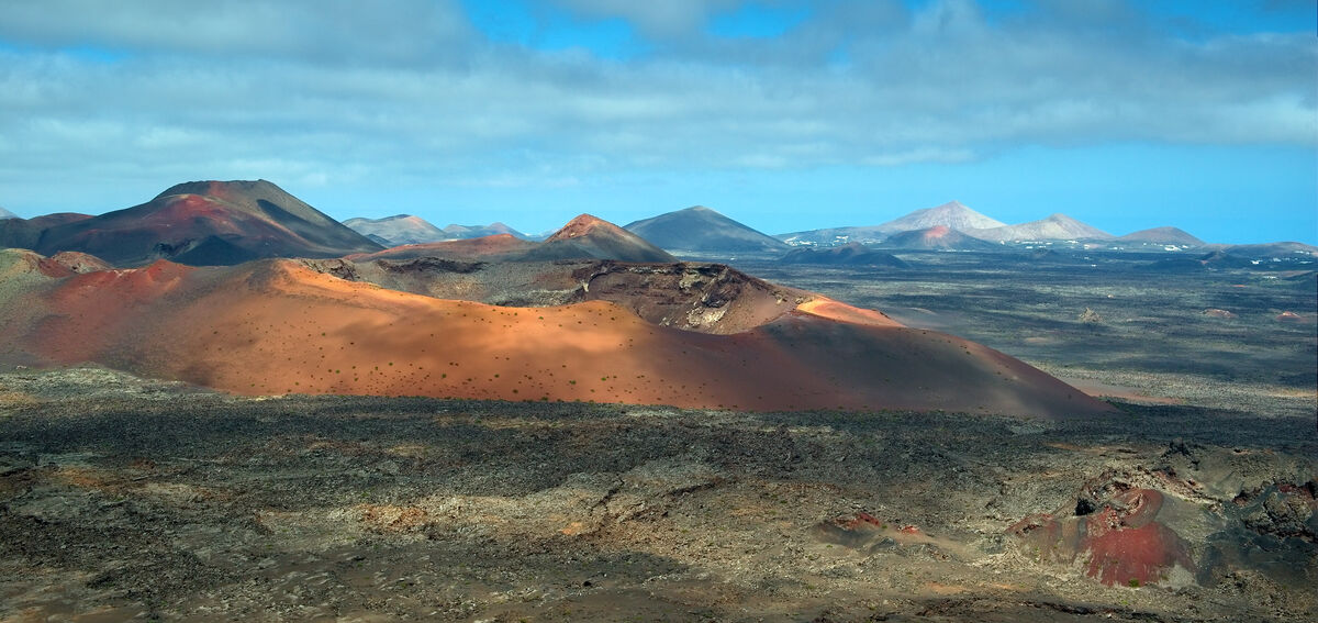 Paysage volcanique du Parc National de Timanfaya avec des champs de lave rouges et noirs a Lanzarote
