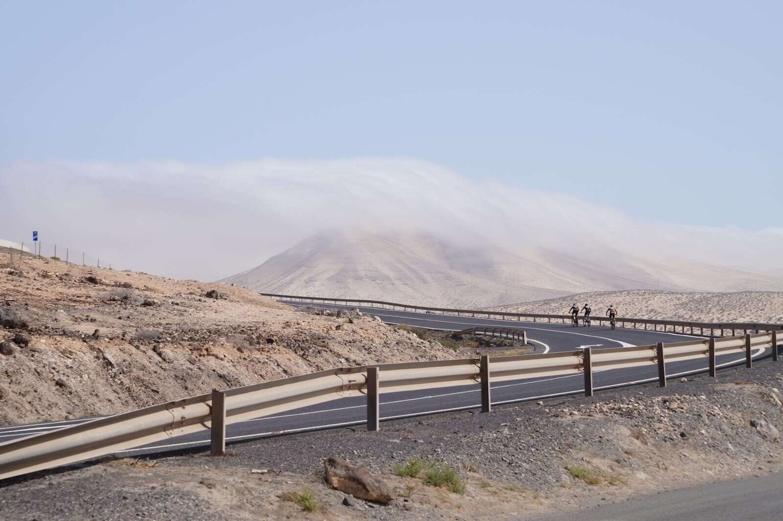 Cyclistes sur route sur une route sinueuse des Canaries dans un paysage aride et montagneux
