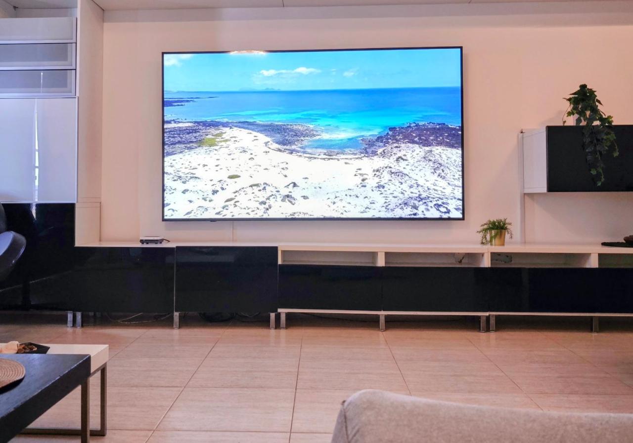 86 inch LG cinema smart TV in the Casa Los Alisios living room showing the Lanzarote coast